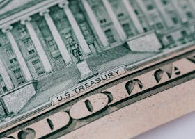 Detailed close-up of the U.S. Treasury text on a dollar bill, showcasing intricate design and financial symbolism.