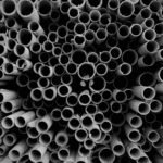 An artistic black and white image of stacked rolls of paper forming an abstract pattern.